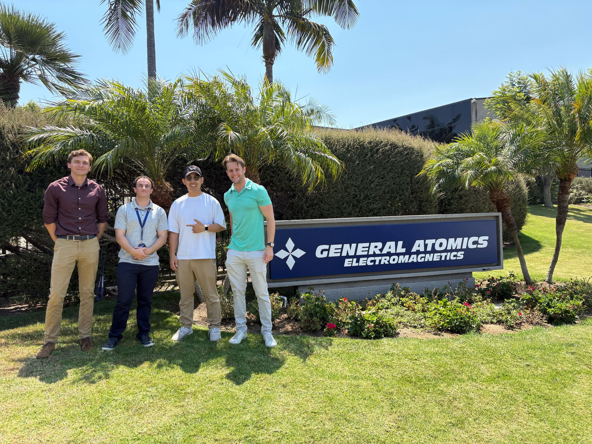 David and three teammates at the General Atomics Electromagnetics sign