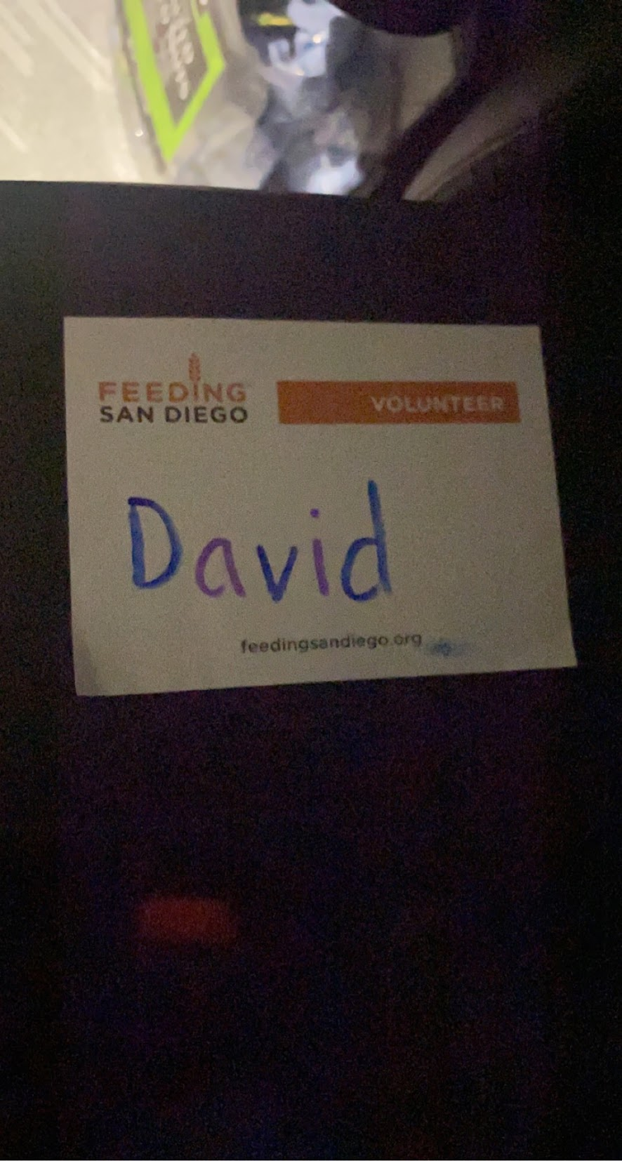 A Feeding San Diego volunteer badge hand-labeled “David”